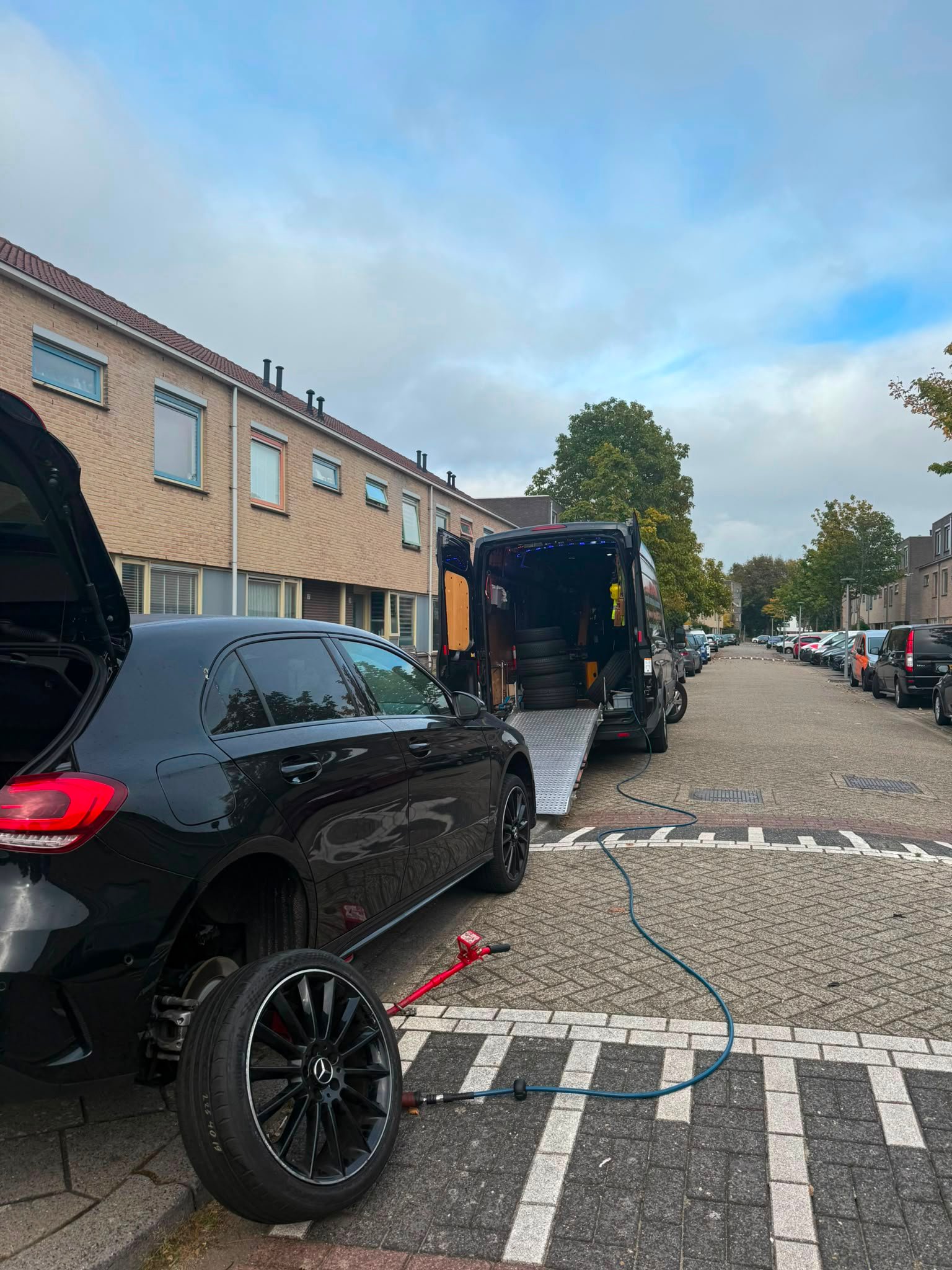 Lekke band vervangen in een woonwijk, voor de deur