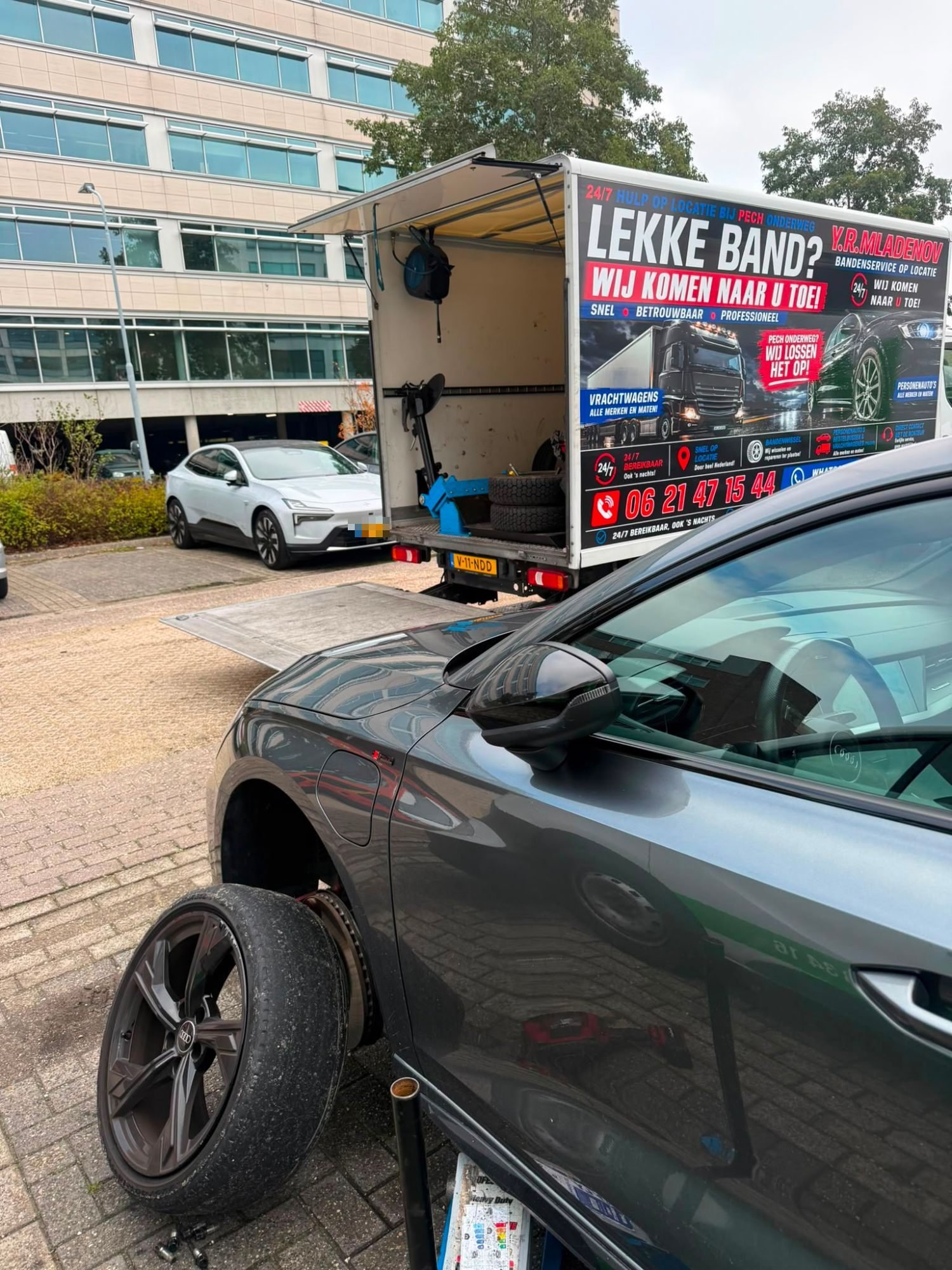 Lekke band vervangen op het parkeerterrein bij een kantoor
