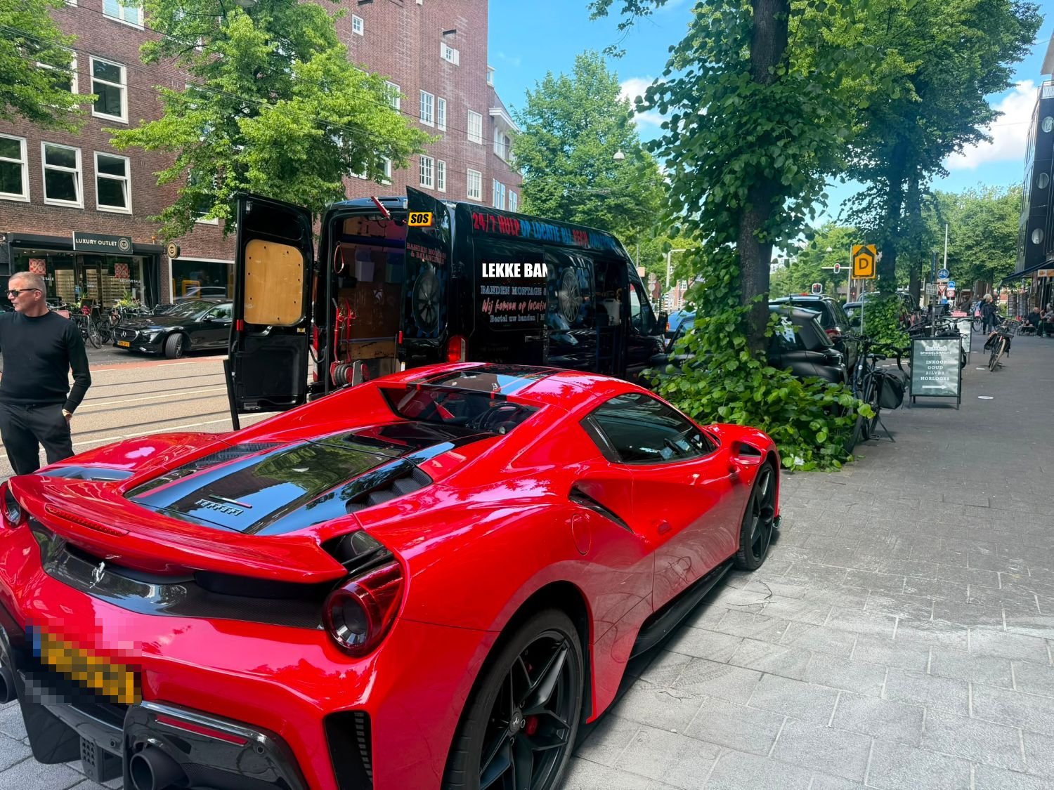 Lekke band van een sportwagen: lekke autoband vervangen op locatie bij een rode Ferrari