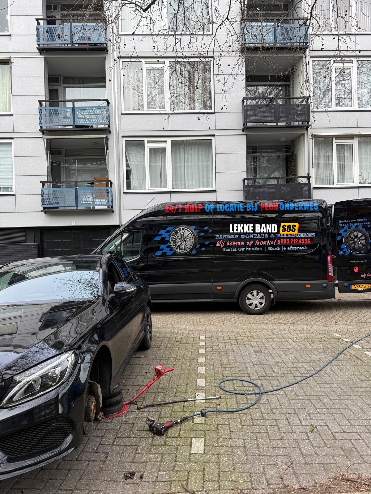 De rijdende werkplaats van Lekke Band SOS op straat, klaar om een lekke band op locatie te vervangen